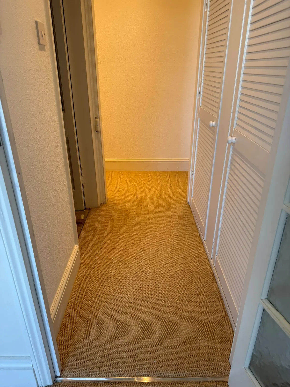 Sisal fitted on a landing beside louvred cupboards
