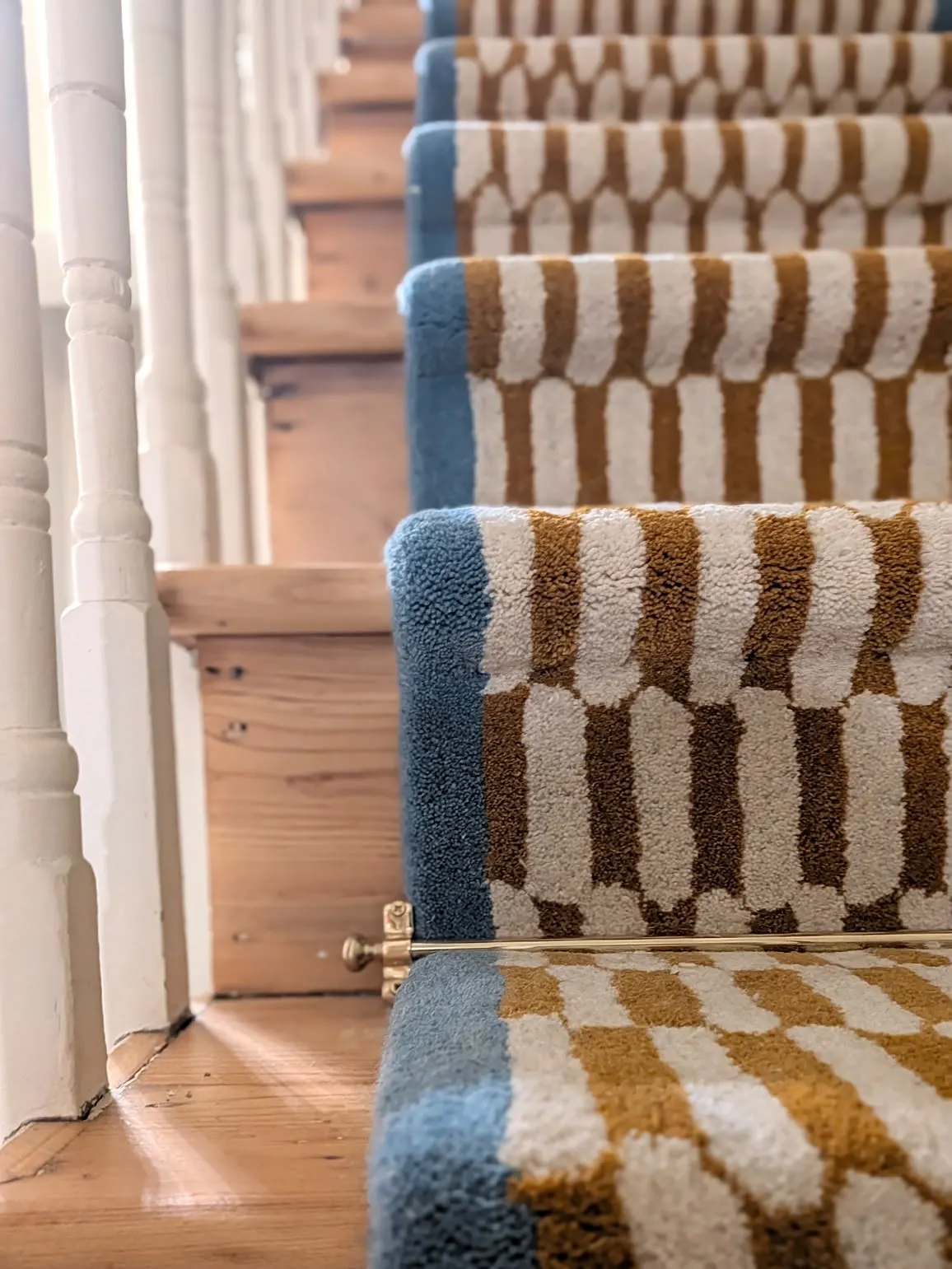 Patterned stair runner held with brass stair rods