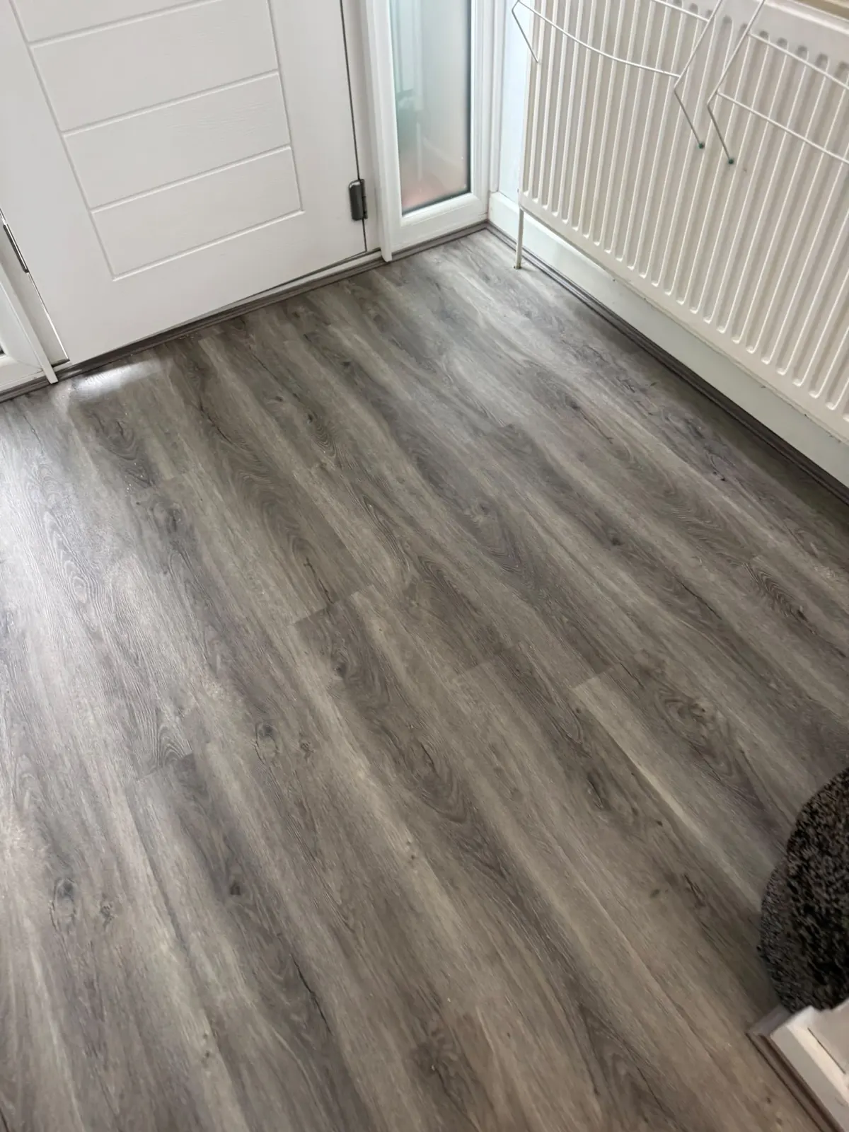 Grey wood-effect floor fitted by a front door