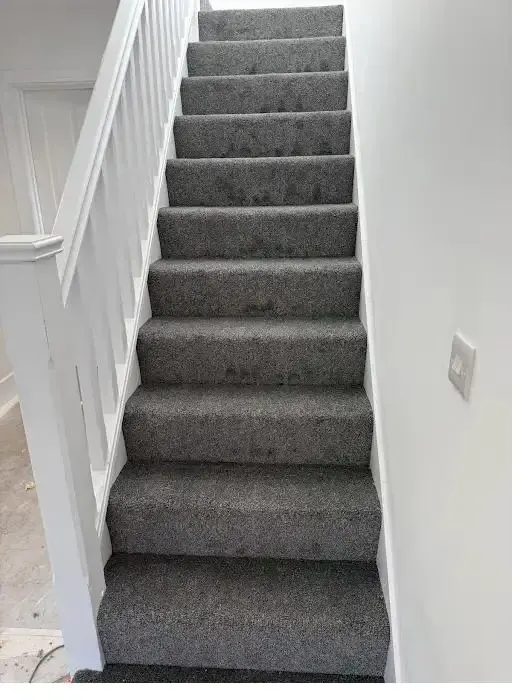 Grey carpet fitted on a straight staircase