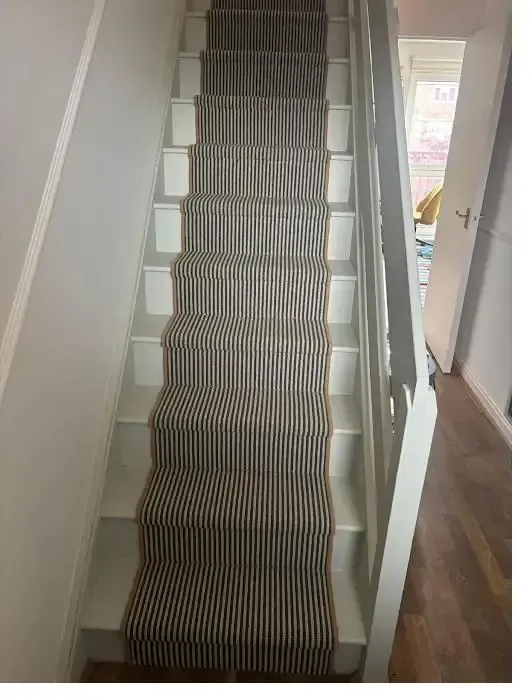 Striped stair runner fitted over a painted staircase