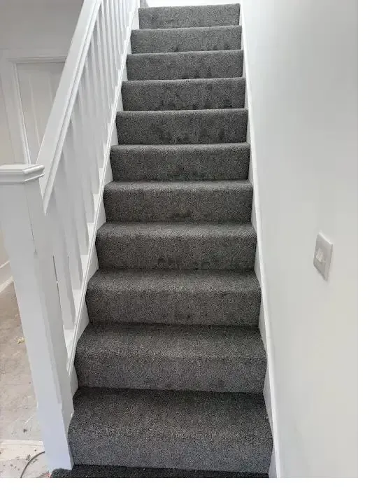 Grey carpet fitted on a straight staircase