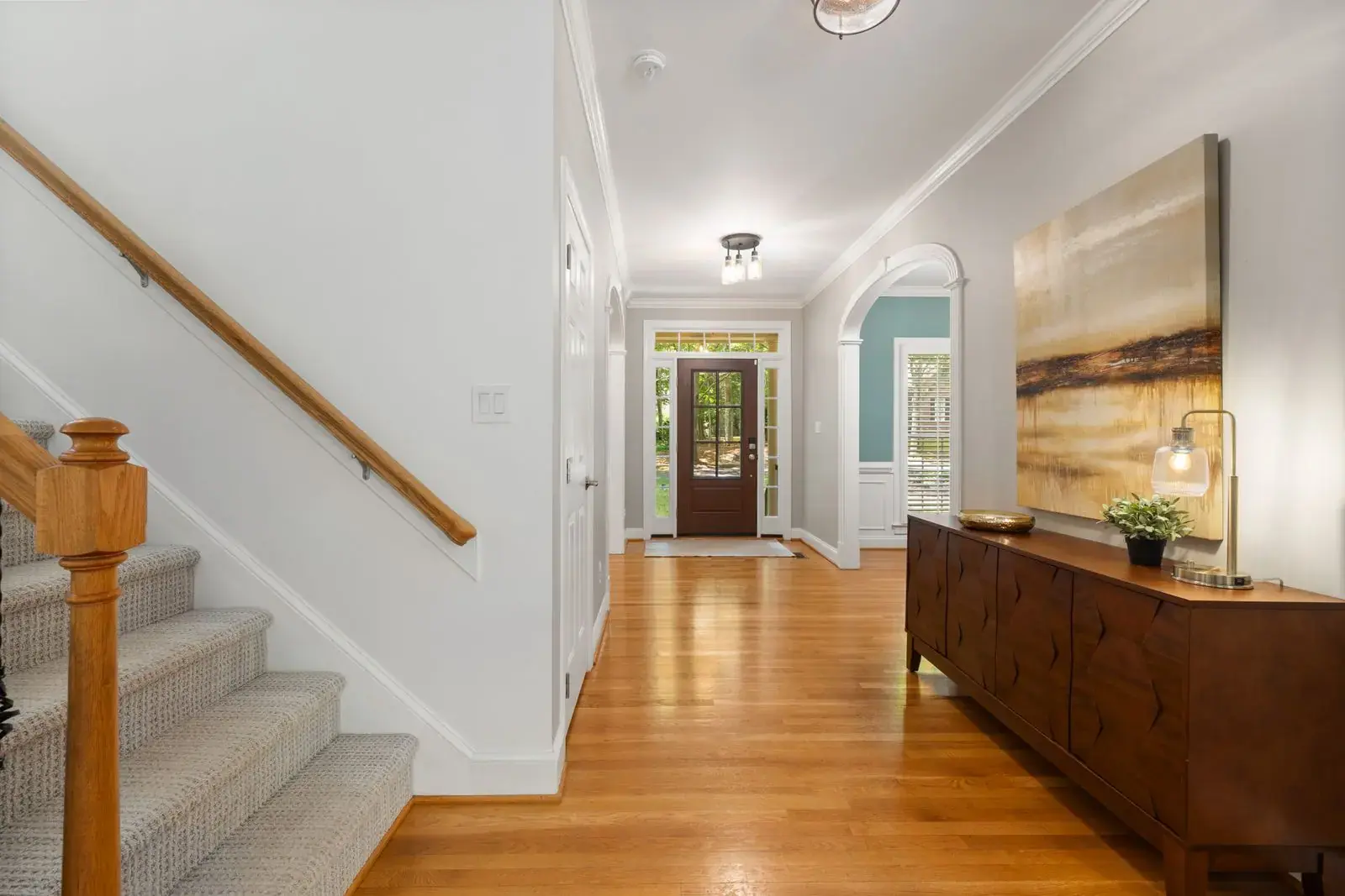 Carpeted stairs beside a wood-floored hallway